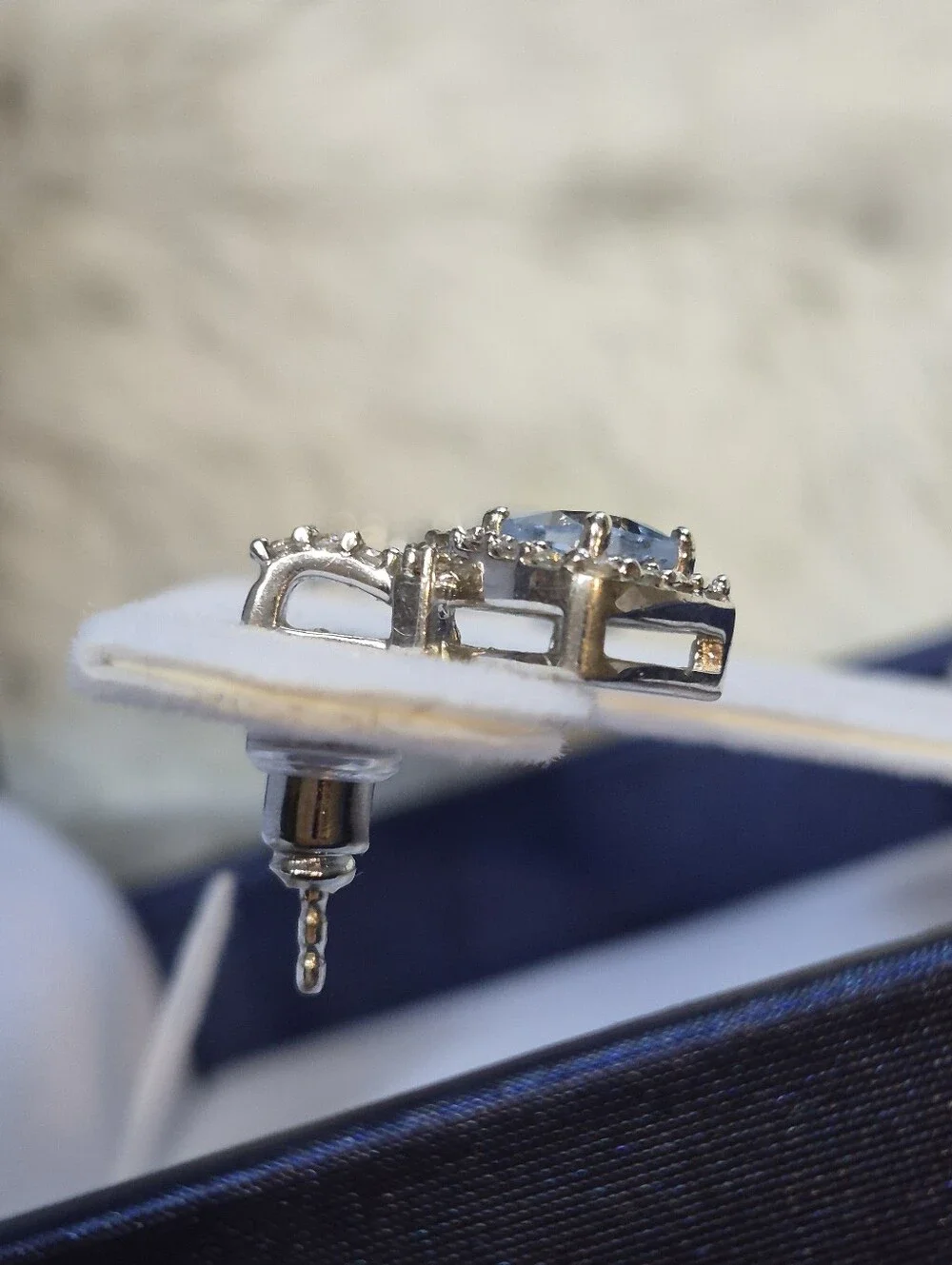 Brighton drop earrings feature a striking cushion-cut blue crystal center